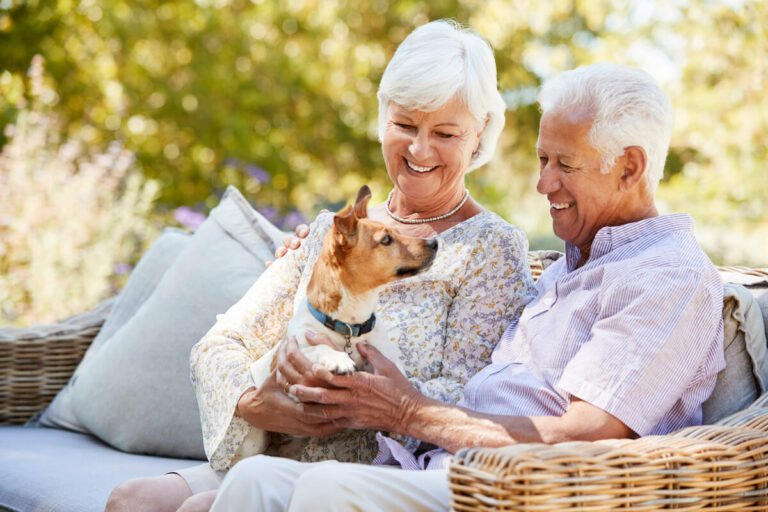 Sage Oak of Lake Charles | Happy senior couple smiling while petting their dog