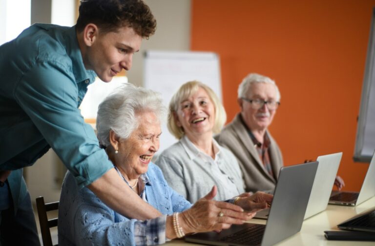 Lake Charles | Group of happy seniors using laptops with an instructor