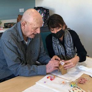 Sage Oak of Lake Charles | Resident making gingerbread house with associate